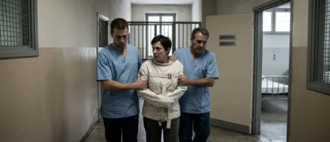 Infermieri con persona legata da camicia di forza